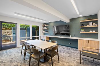 A dining room with a table and chairs.